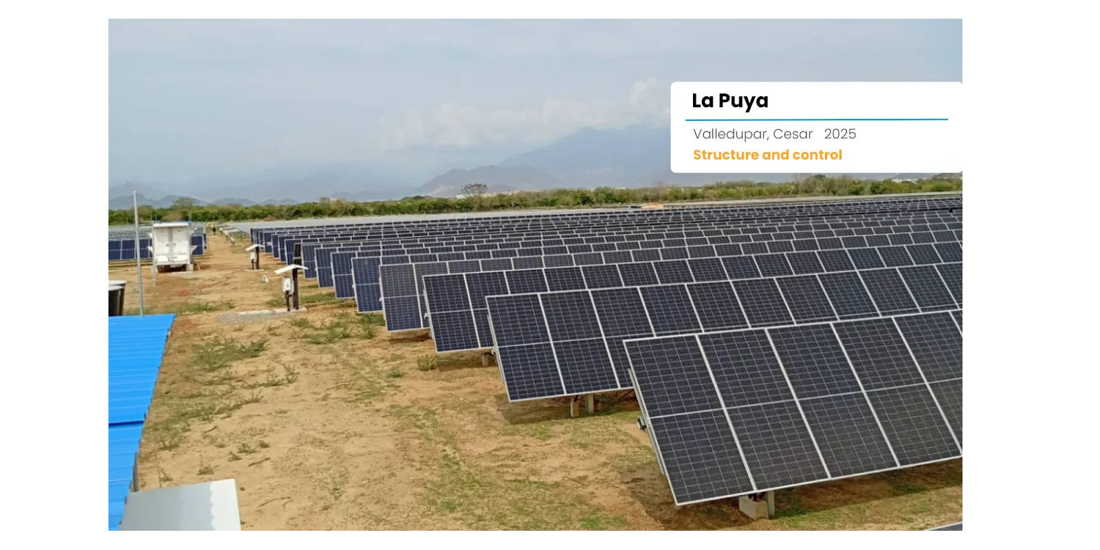 Instalación de paneles solares en un campo verde con montañas al fondo durante el atardecer